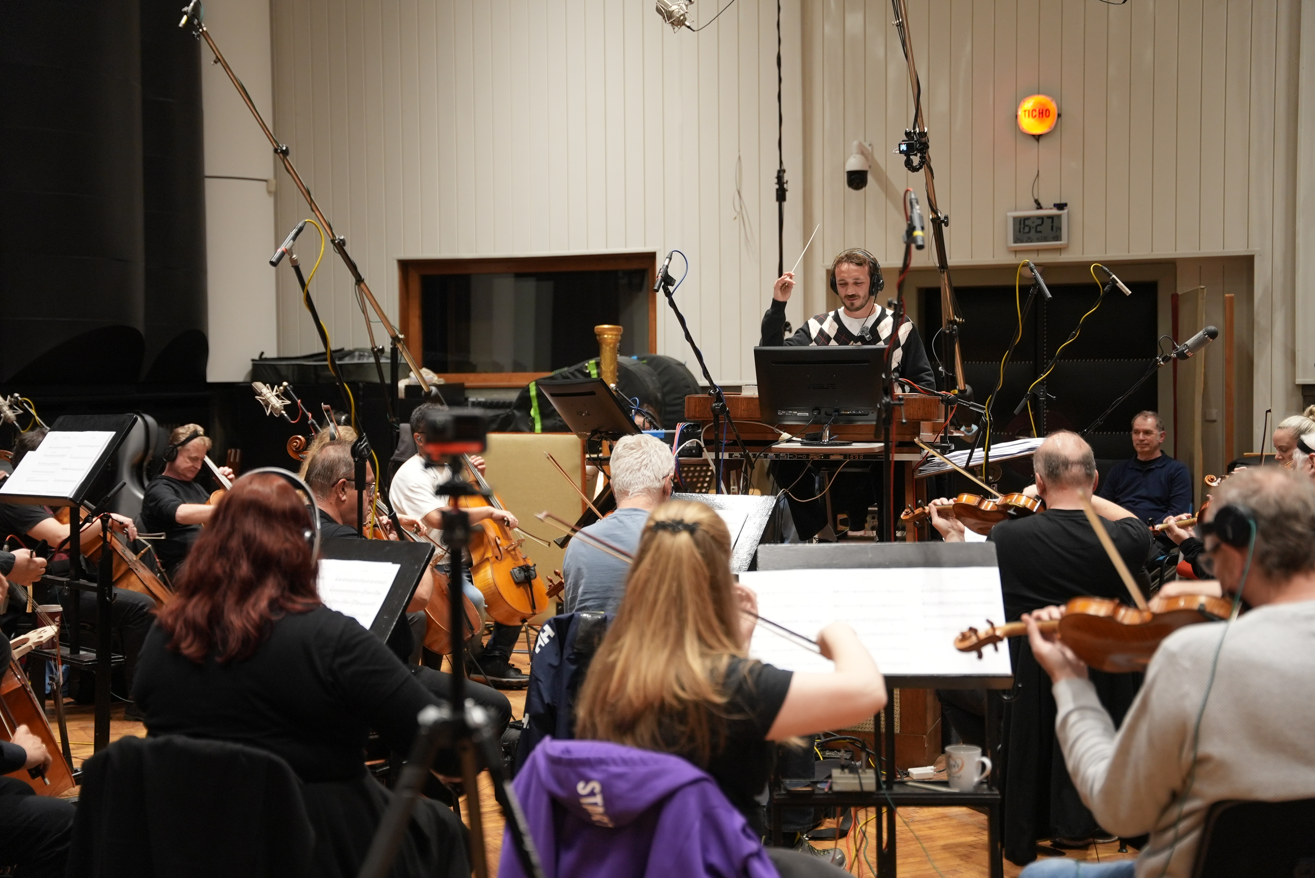 Richard Jones conducting an orchestra during the Galactic Odyssey recording session